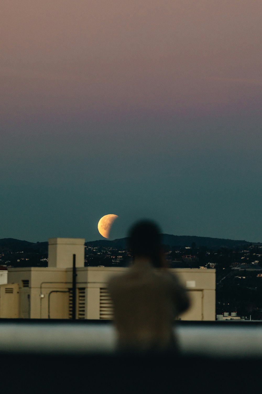 person standing during nighttime with crescent moon