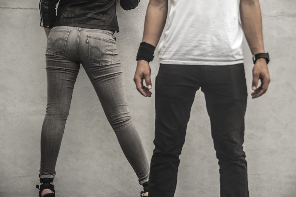 man in black pants beside woman in gray skinny jeans