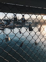 gray chain link with padlock over body of water