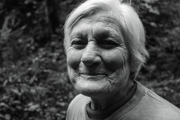 A serene scene of an elderly person smiling while talking on a simple phone, with soft pastel backgrounds.
