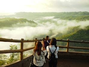 three woman standing on mountain cliff