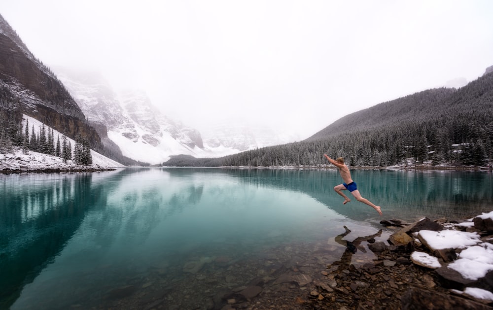 person jump in body of water during day time