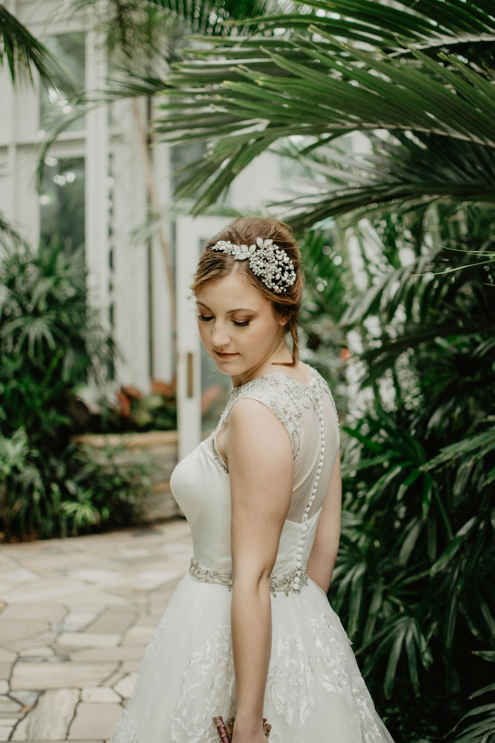 Mujer con vestido de novia blanco cerca del árbol