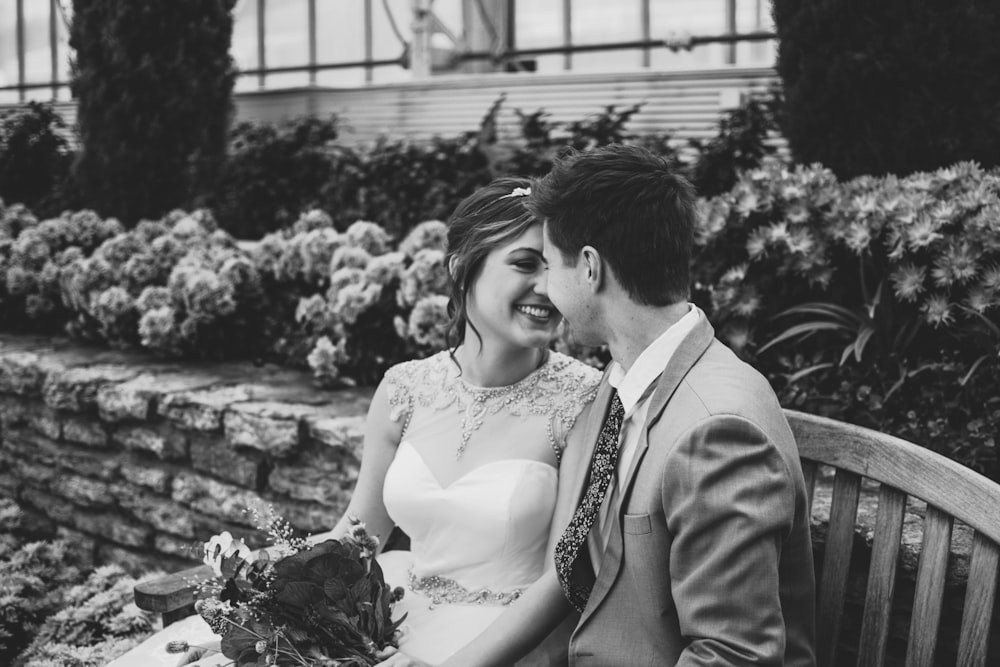 grayscape photo of newlywed sitting on bench