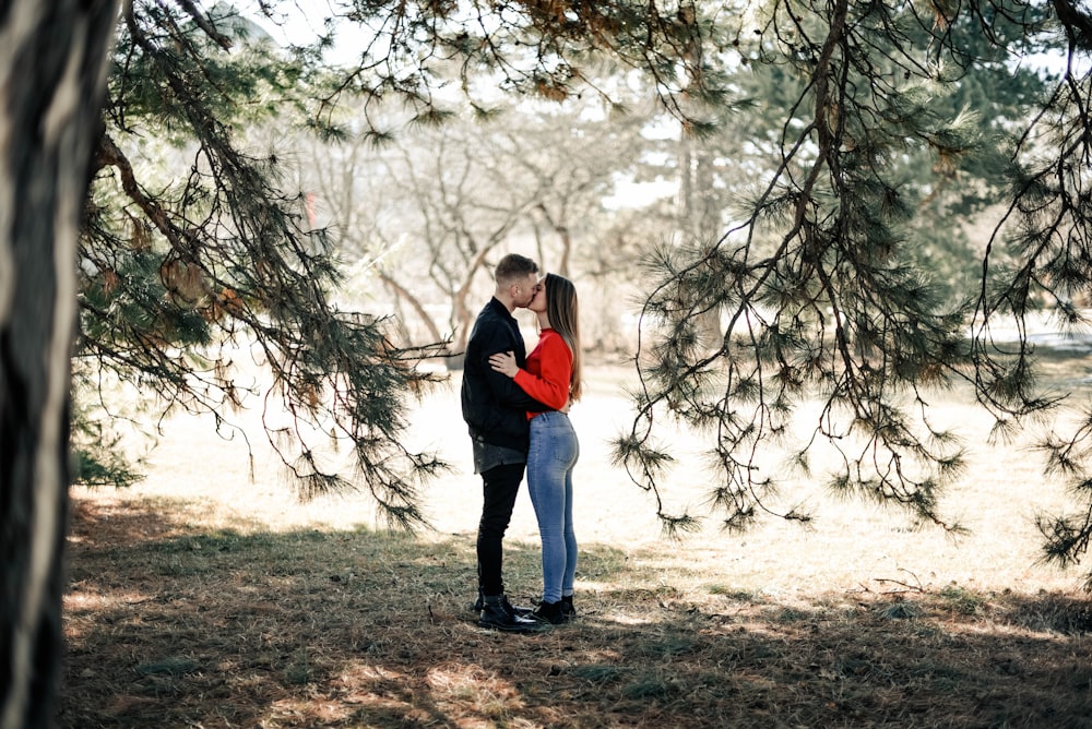 homem e mulher se beijando debaixo da árvore