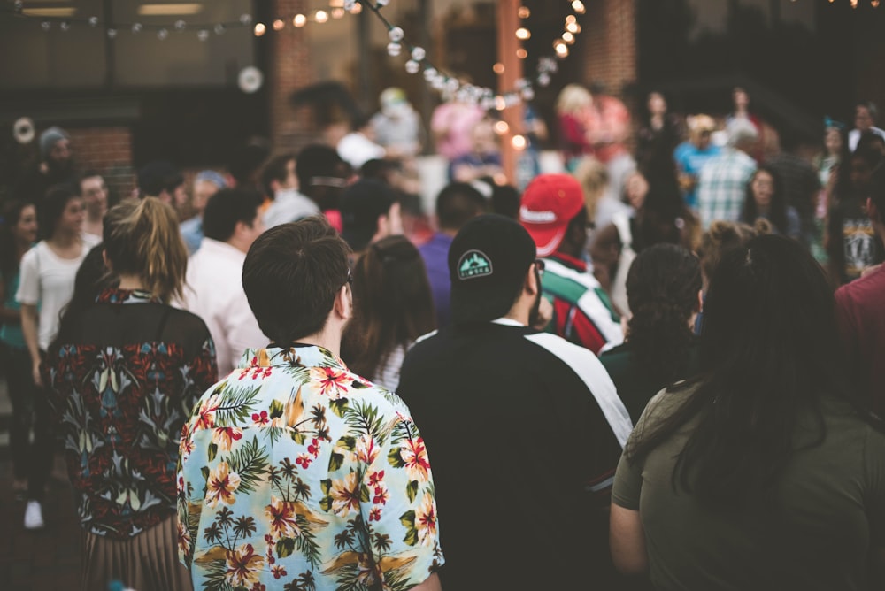 group of people standing under string lights