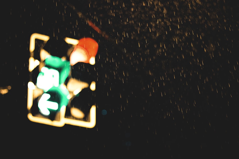 a traffic light in the rain at night