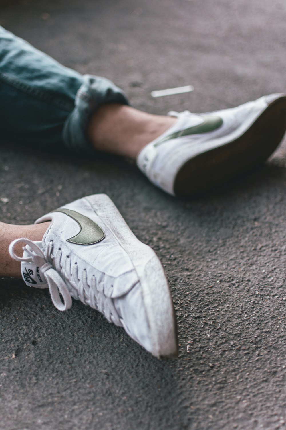 persona che indossa un paio di scarpe da ginnastica Nike bianche