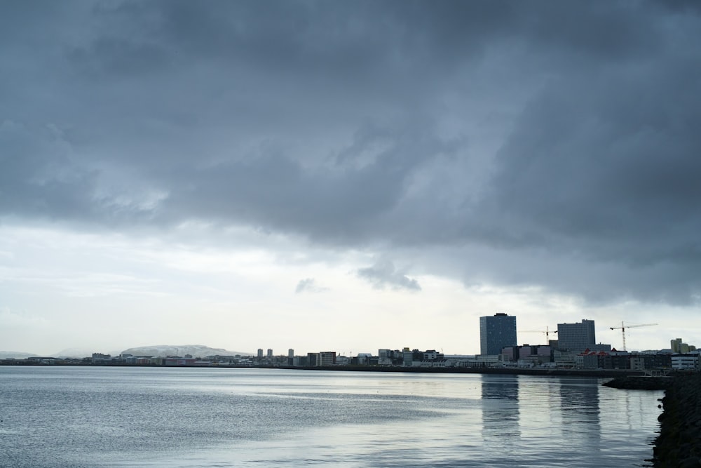 specchio d'acqua vicino agli edifici della città sotto il cielo nuvoloso durante il giorno