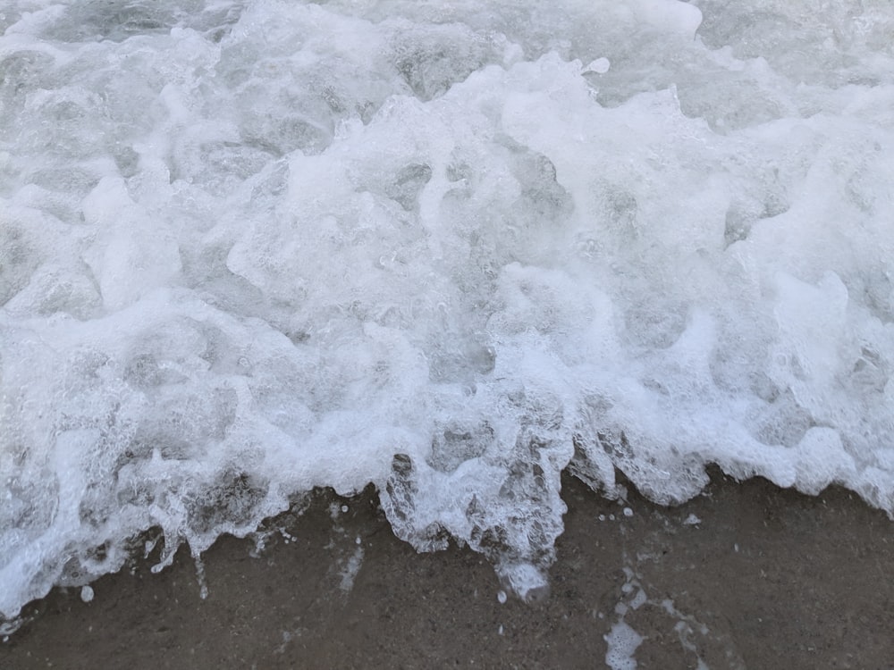 white bubbling water on beige soil at daytime