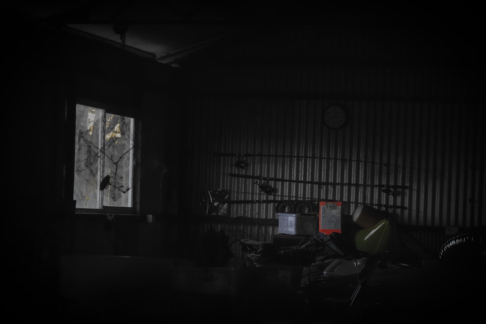 a dark room with a clock and a window