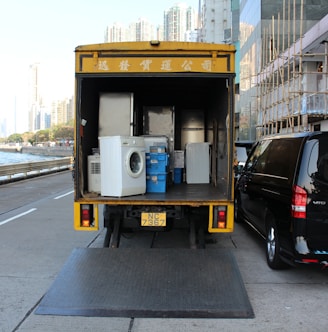 white front-load washer in yellow delivery truck