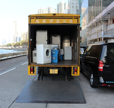 white front-load washer in yellow delivery truck