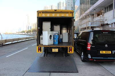 white front-load washer in yellow delivery truck moving teams background