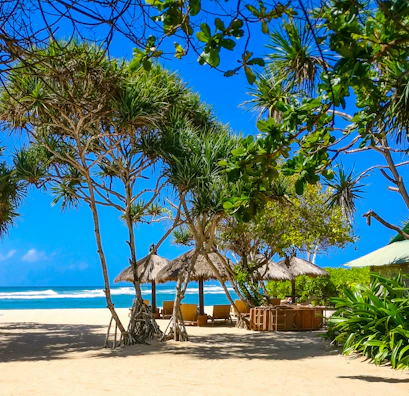 four huts at beach under blue skies during daytime
