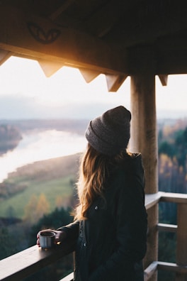 Couple enjoying a morning coffee on the balcony of a chalet surrounded by nature.