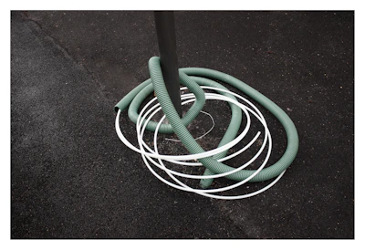 Close-up of a flexible PVC hose coiled neatly on a factory floor.