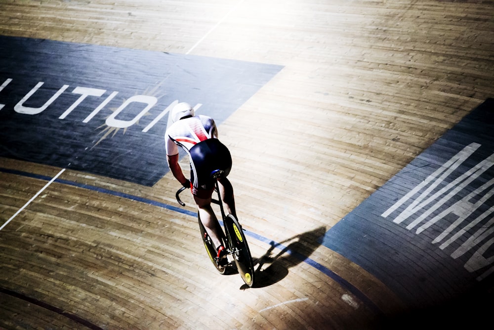 man riding bike on indoor cycling field