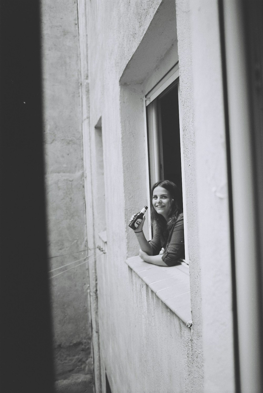 woman holding beer bottle on window