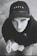 A young person gazes upward while holding a cup. They are wearing a black cap with the word 'YOUTH' on it and a dark hoodie. The image is in black and white, contributing to a nostalgic or contemplative atmosphere.