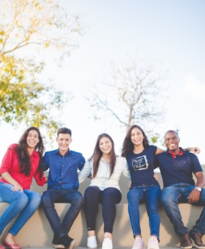 group of people sitting on bench near trees duting daytime