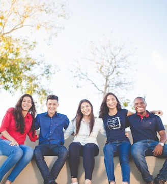 group of people sitting on bench near trees duting daytime