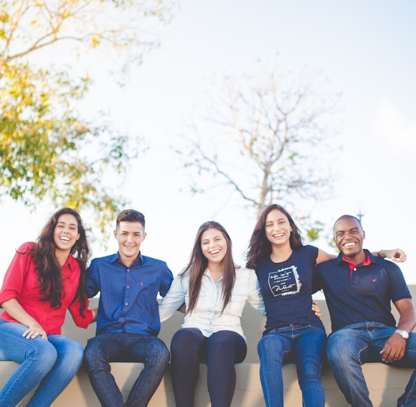 group of people sitting on bench near trees duting daytime