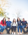 group of people sitting on bench near trees duting daytime