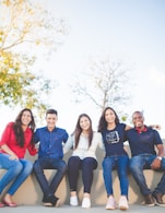 group of people sitting on bench near trees duting daytime