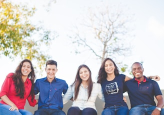 group of people sitting on bench near trees duting daytime