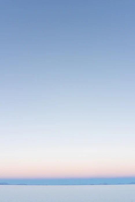 A couple sitting on a kitchen table at dusk, mid-conversation, the quality of the silence between them suggesting a difficult repair