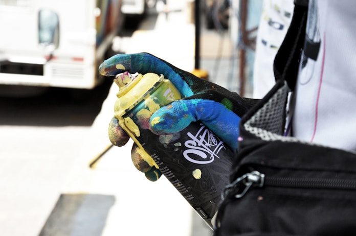 person holding black and yellow spray bottle