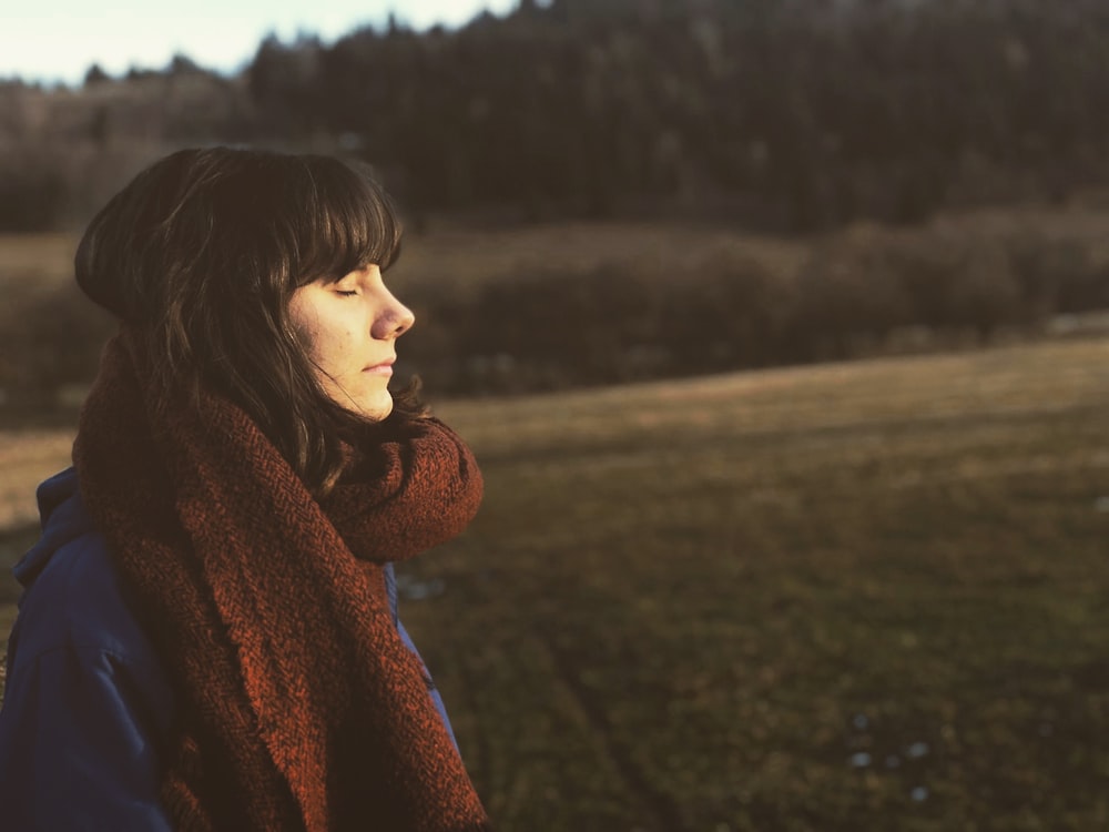 woman close eye standing on grass field