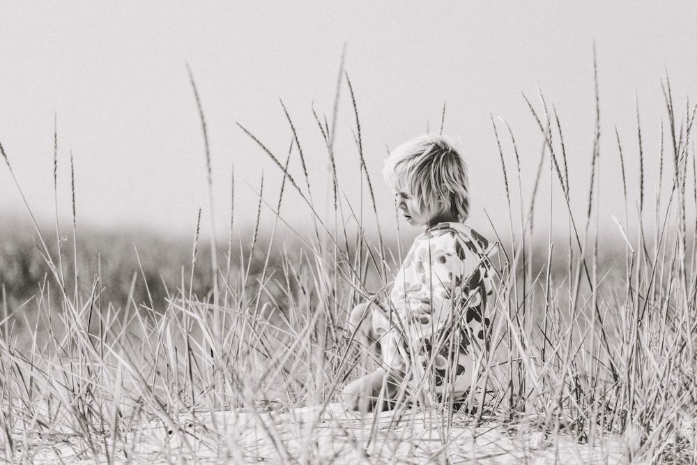 grayscale photo of child sitting