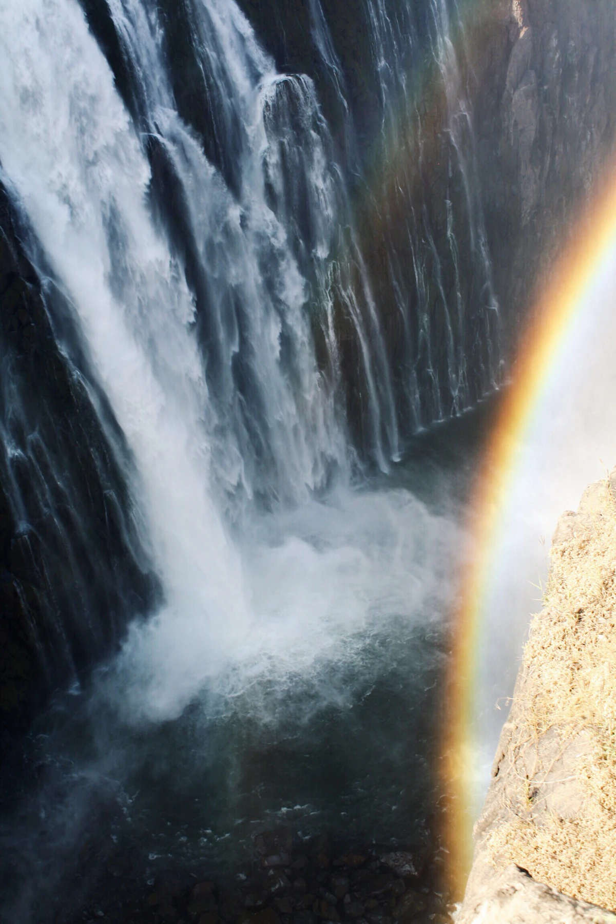Victoria Falls seen from the Zambian side — the full width of the falls visible through mist and spray