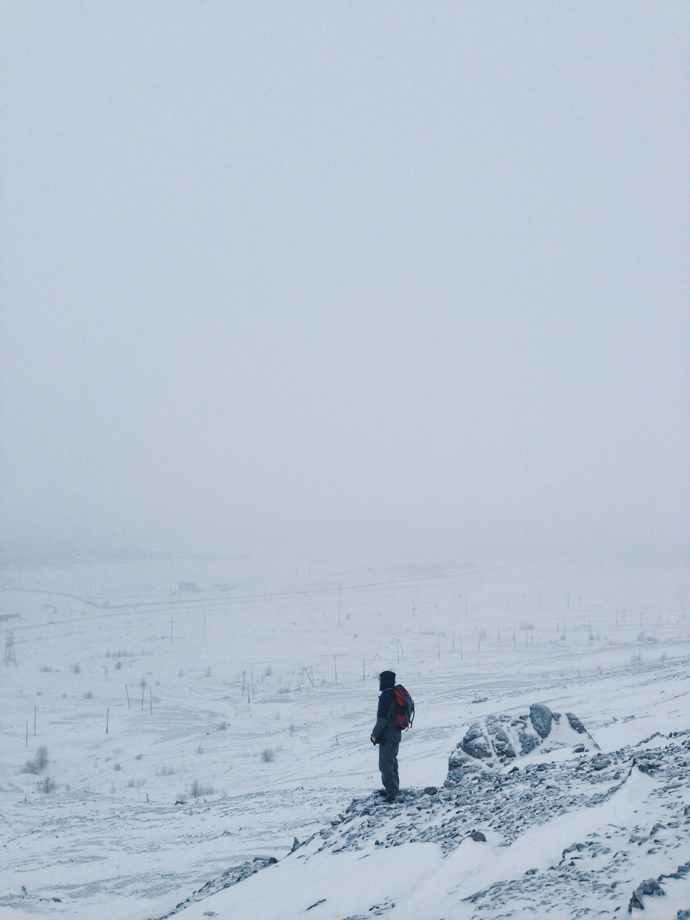 person standing on snow covered cliff