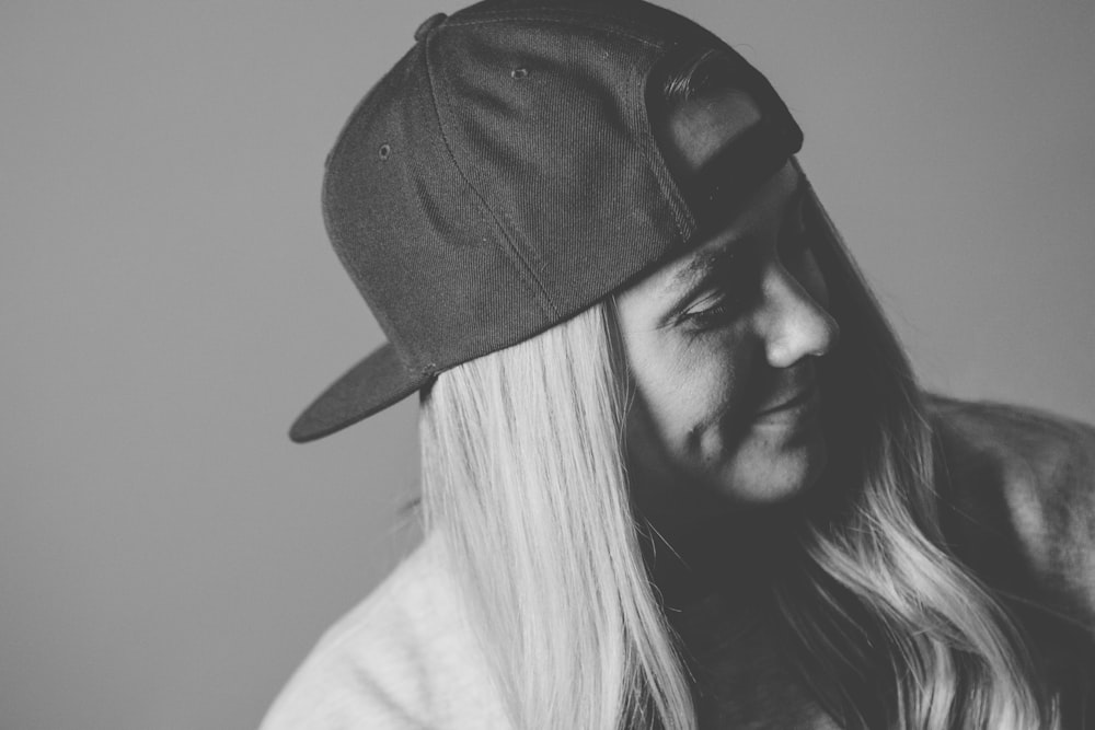 a black and white photo of a woman wearing a hat