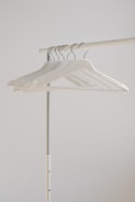 white clothes hangers hanging on rack