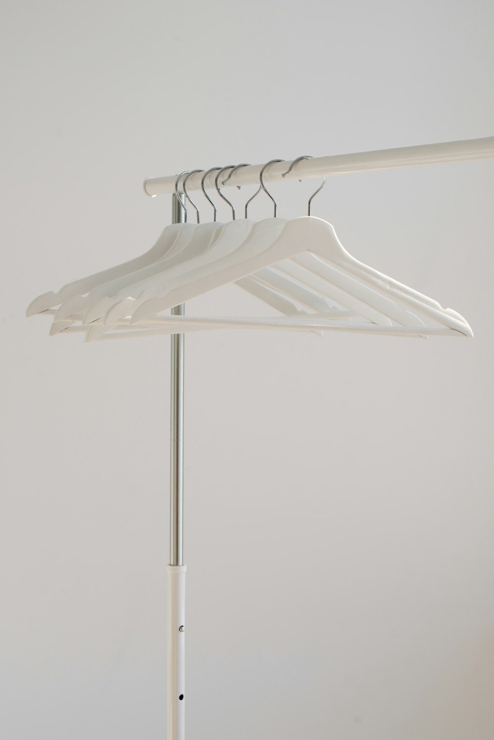 weiße Kleiderbügel, die auf einem Ständer hängen
