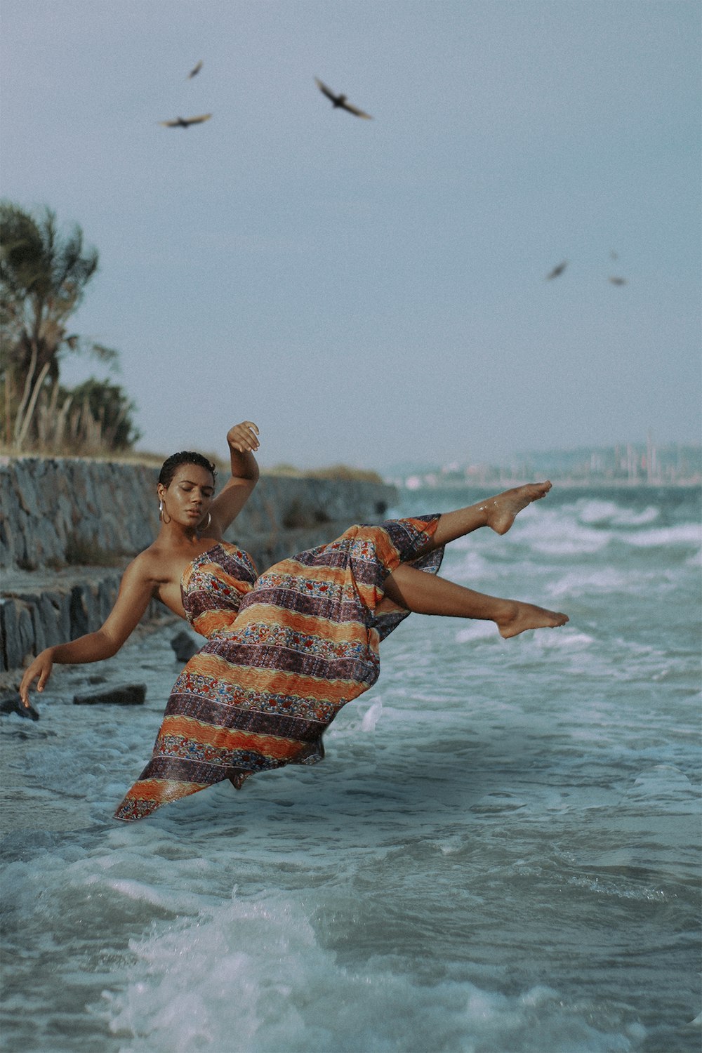 Um homem com um vestido laranja e azul está na água