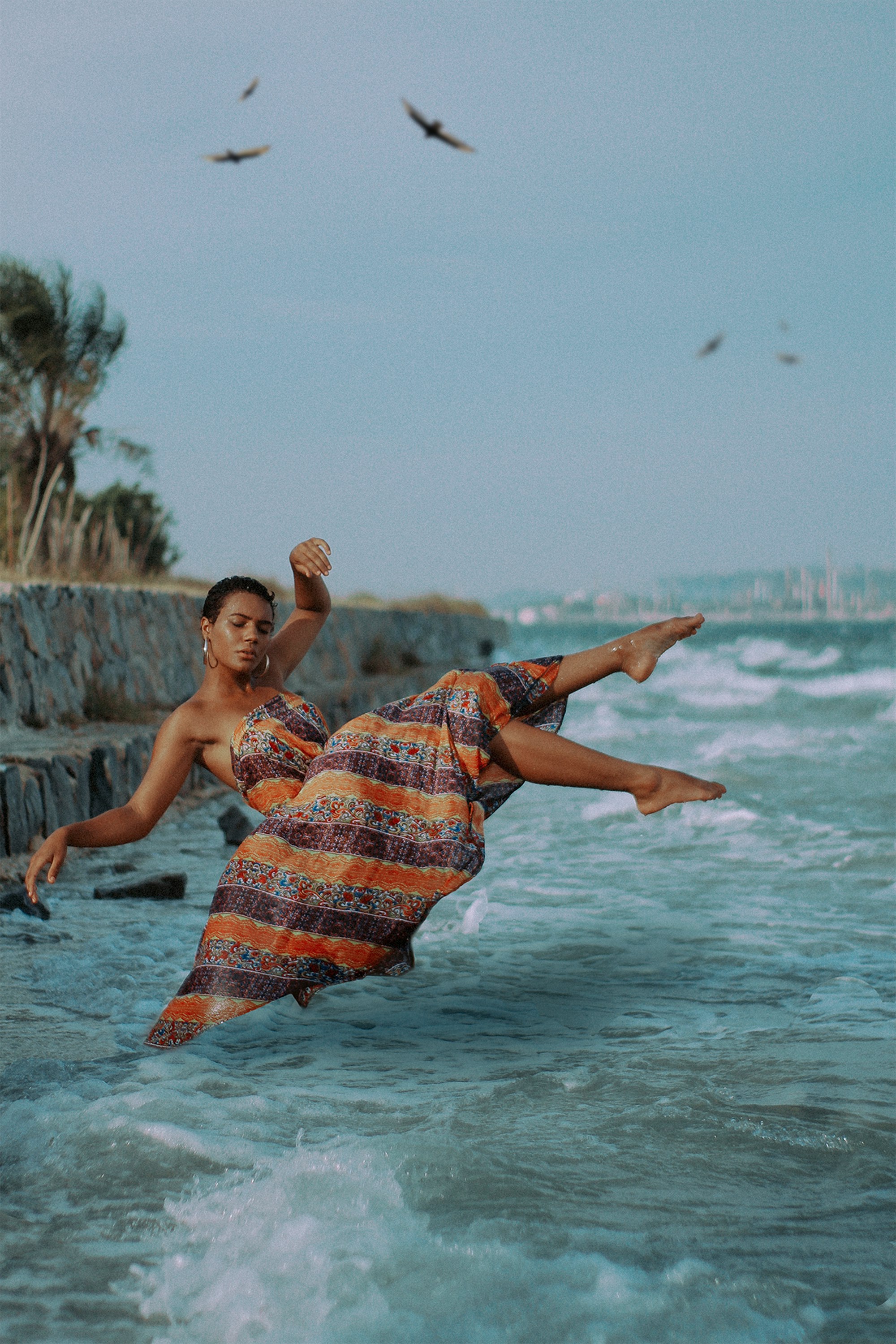 a man in an orange and blue dress is in the water