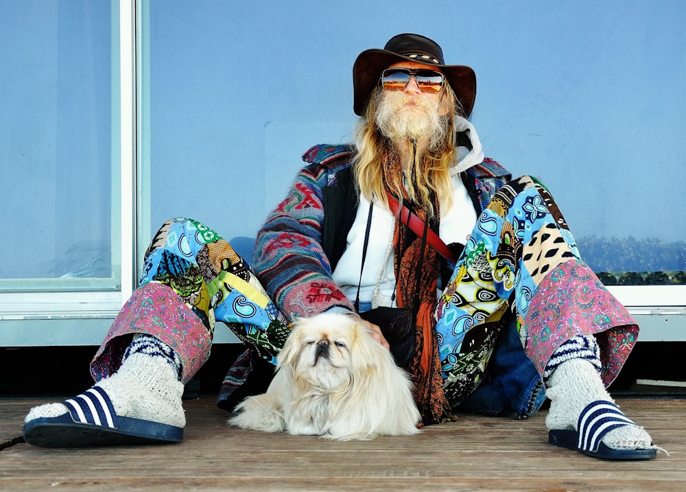 man sitting on floor beside dog during daytime