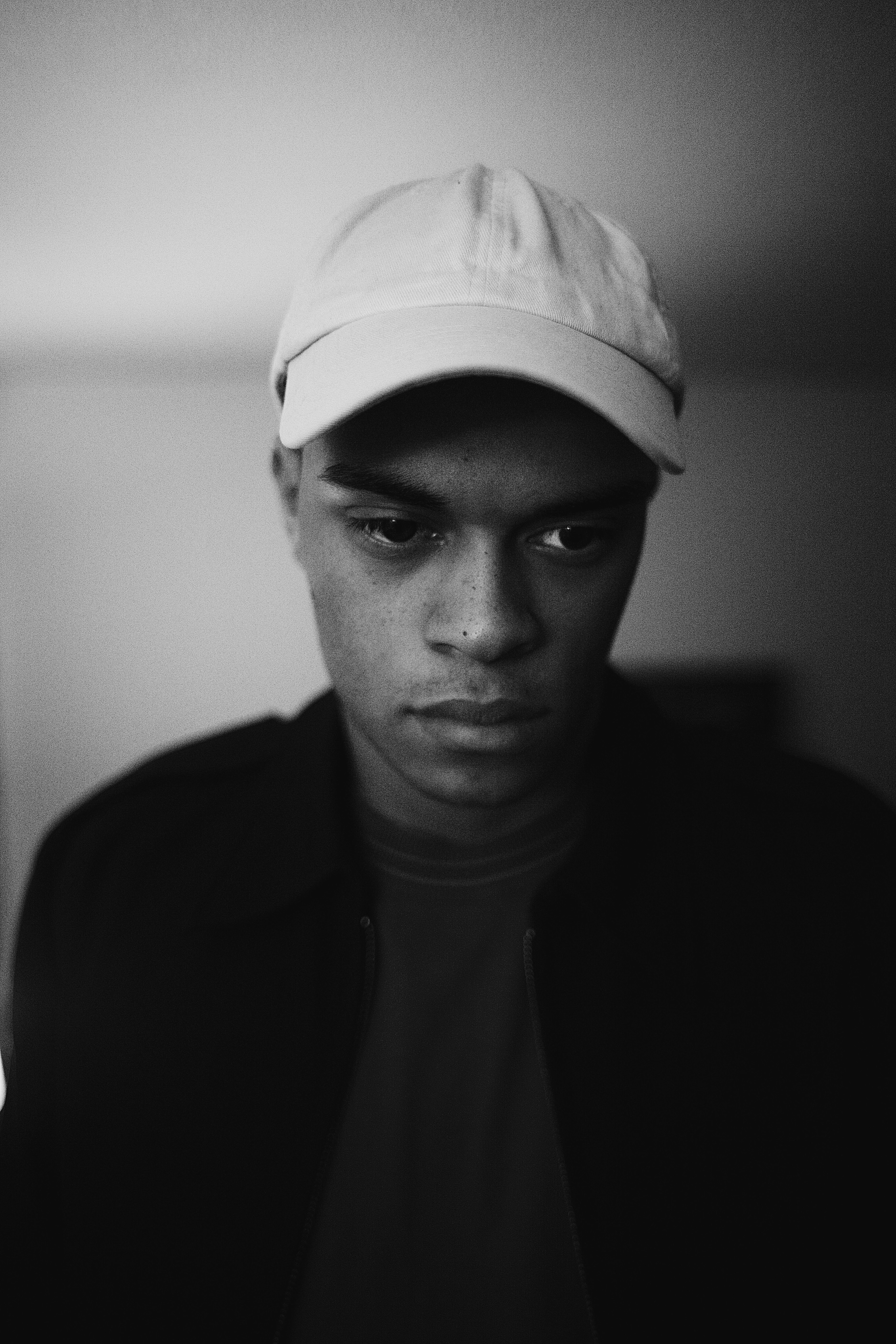 grayscale photo of man wearing cap