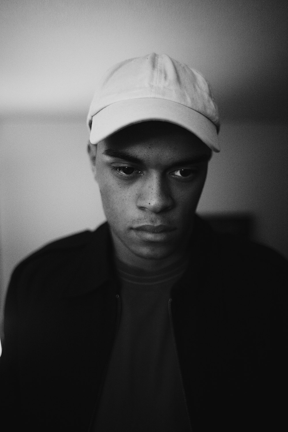 grayscale photo of man wearing cap