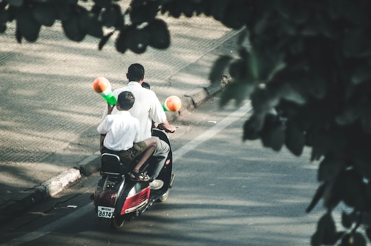 man and boys riding on motorcycle in Shaniwar Wada Fort India