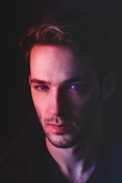 An actor deeply focused during a coaching session in a minimalist studio with soft blue lighting.