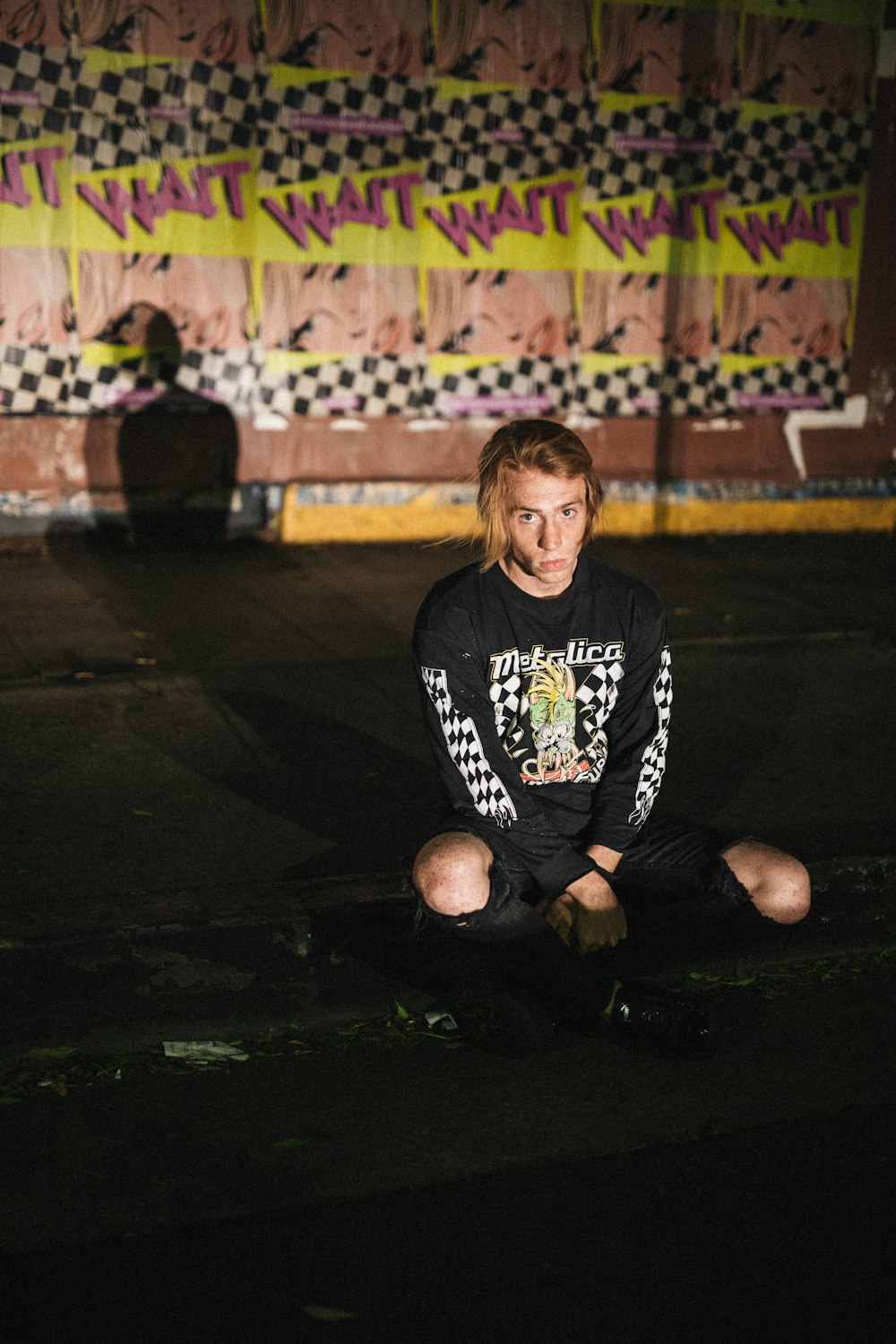 man sitting on concrete pavement