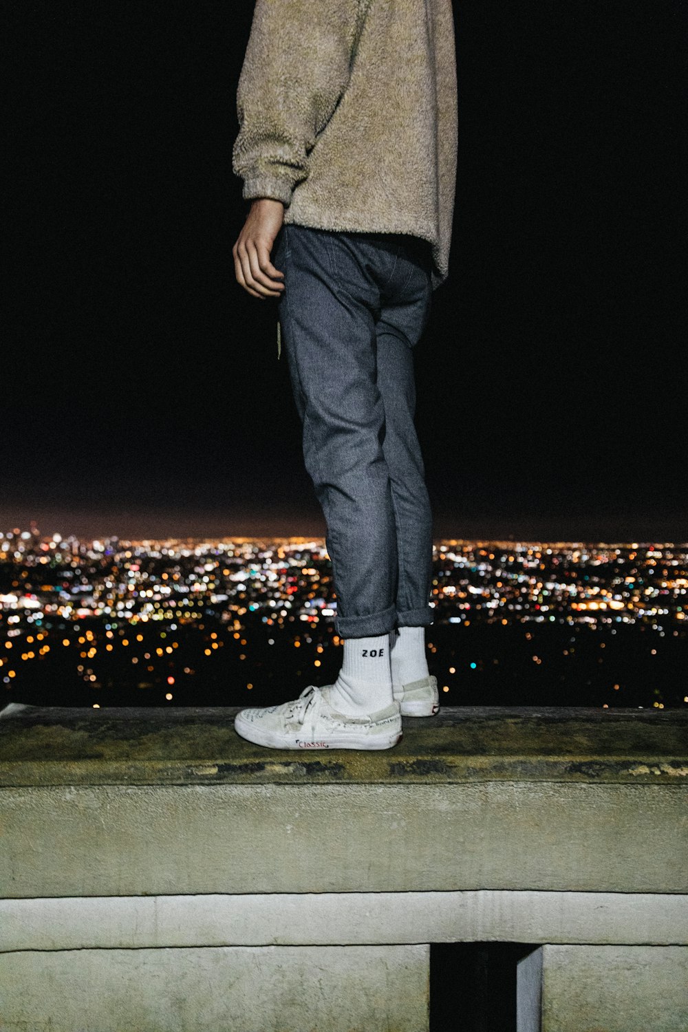 person standing on a gray concrete surface facing city