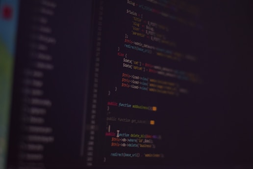 Code snippets of smart contracts displayed on a laptop screen with a futuristic background.