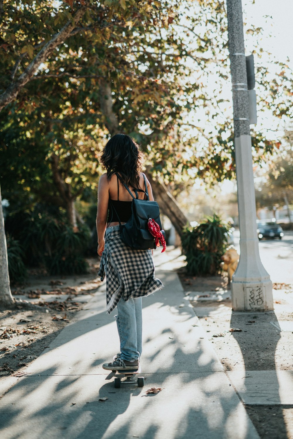 woman riding on skateboard on sidewalk